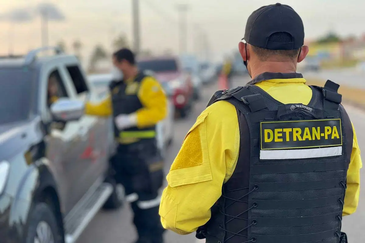 Policial realizando blitz da Lei Seca para verificar embriaguez ao volante