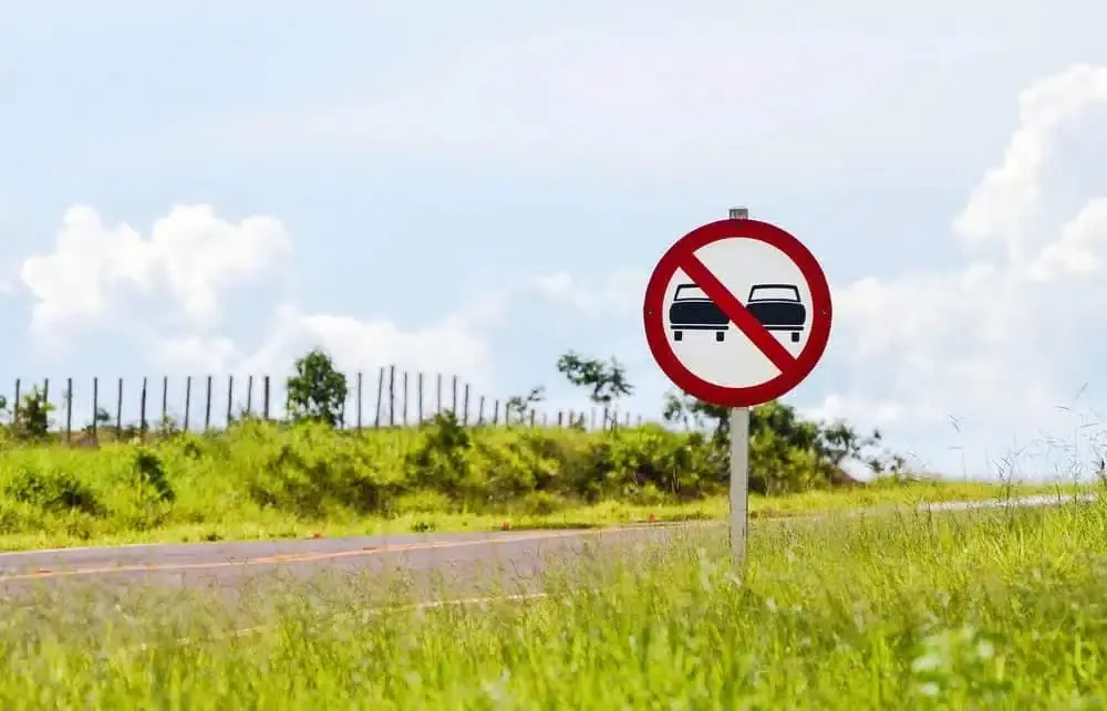 Rodovia com faixa contínua amarela sinalizando proibição de ultrapassagem na via